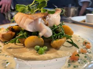 um prato de alimentos com carne e legumes sobre ele em The Swan Inn Swinbrook em Burford