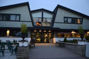 a hotel with tables and chairs in front of a building at Hotel Småland in Skillingaryd