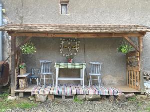 a wooden gazebo with a table and two chairs at Vándor Székely Vendégház in Nagybörzsöny