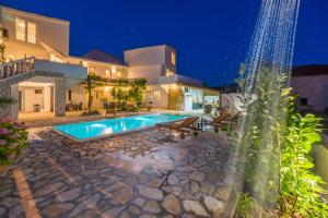 Villa con piscina por la noche en Apartments Barbara, en Tribunj