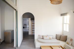 a living room with a white couch and a table at Central Hostel Oia in Oia