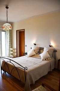 una camera da letto con un grande letto con lenzuola e cuscini bianchi di Villa Viuli a Torre del Greco