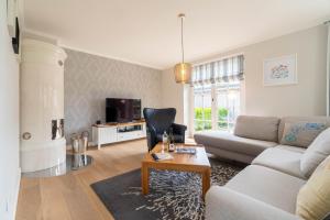 ein Wohnzimmer mit Sofa und Tisch in der Unterkunft Haus Sterntaucher in Wrixum