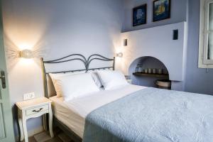 a bedroom with a bed with a blue wall at Ponente in Symi
