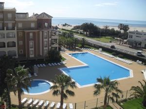 an overhead view of a large swimming pool next to a building at Apartamentos Isla Canela y Punta del Moral in Isla Canela
