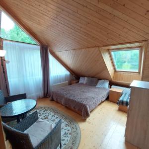 a bedroom with a bed and a table in a attic at Trakai Village apartments in Jovariškės