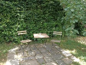 two chairs and a wooden table in front of a hedge at L'échappée au jardin, yourte bucolique in Godinne
