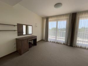a room with a television and a desk and windows at Apartments in Peter House in Sunny Beach