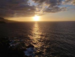 una puesta de sol sobre el océano con la puesta de sol en SUNSET HOME wifi, en Los Realejos