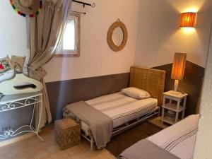 a small room with a bed and a mirror at Villa Salvatore in Ghazoua