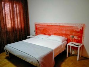 ein Schlafzimmer mit einem Bett und einer roten Backsteinwand in der Unterkunft CASA DE NELLA in Porto San Giorgio