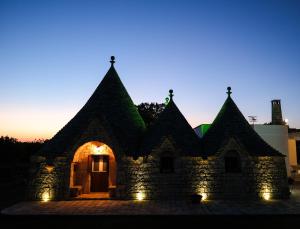 an old building with lights on it at night at TRULLO ELVIRA & LUIGI in Monopoli