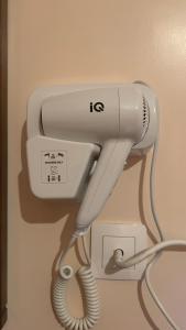 a white hairdryer hanging on a wall at Hotel Cosmos in Athens