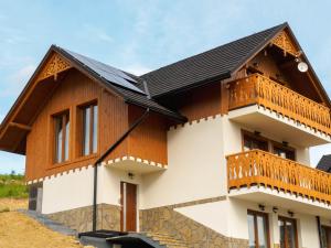 una casa con tetto in legno e balcone di Domek na Słonej a Szczawnica