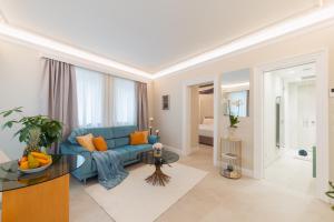 uma sala de estar com um sofá azul e uma mesa em Naxi Suites em Taormina