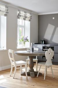 une salle à manger blanche avec une table et des chaises dans l'établissement Ferienwohnung Lotte, à Waabs