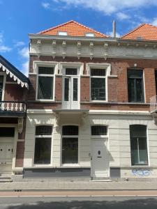 une maison en briques avec des portes blanches dans une rue dans l'établissement D10 Apartments, à Breda