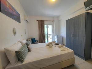 a large white bed in a room with a window at Sea La Vie - Studios Maria in Limenaria