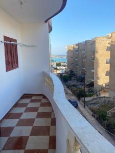 a balcony with a checkered floor and a view at Ashour Tower Ramy Abdulla For Families only in Marsa Matruh