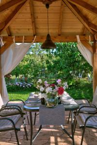 un tavolo con sedie e un vaso di fiori sopra di Villa Doreta a Roda