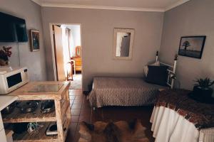 a room with two beds and a television and a table at Garden cottage in Cape Town