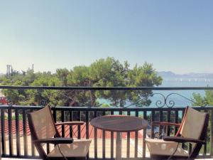 a table and chairs on a balcony with a view of the water at Danae Hotel in Egina