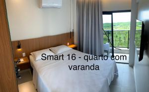 a hotel room with a white bed and a window at Salinas Premium Resort LUXO in Salinópolis