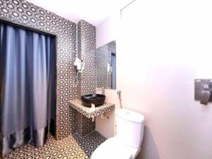 a bathroom with a toilet and a shower and a sink at Raintree Boutique Hotel in Kajang
