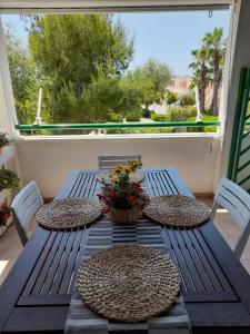 una mesa azul con sillas y una cesta de flores. en Casamarina Cristal Village en Campomarino