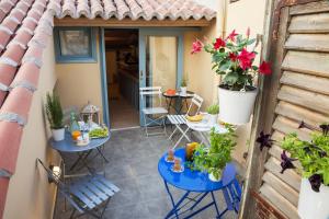 a balcony with two tables and flowers on it at Nafplion 1841 in Nafplio