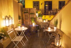 a patio with tables and chairs and a balcony at Nafplion 1841 in Nafplio