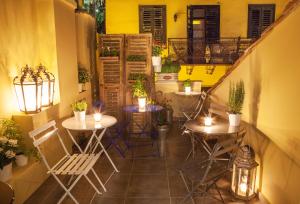 patio ze stołami i krzesłami oraz balkonem w obiekcie Nafplion 1841 w Nauplionie