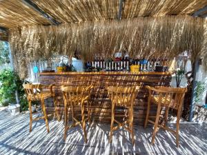 a bar with wooden chairs and a wooden counter with a bar at Alaçatı La Vista in Alaçatı