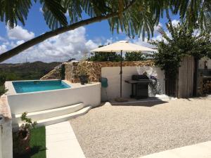 een achtertuin met een zwembad en een parasol bij Quinta Vale de Luz in Silves