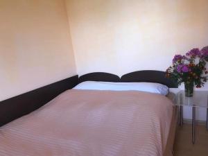 a bedroom with a bed with a vase of flowers at Khutorok Svergio in Chesnivka