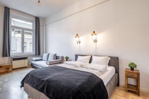 ブダペストにあるCentral Luxury Apartment with ACのベッドルーム(大型ベッド1台、ソファ付)