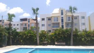 a building with palm trees and a swimming pool at cómodo first floor in Santiago de los Caballeros