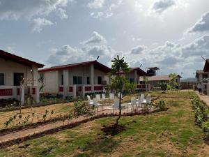 a row of white chairs in a yard next to a house at Casa De Recurso in Ghātghar