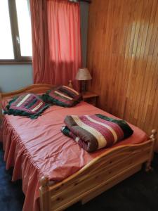a bedroom with a wooden bed with two pillows on it at Appartement La Toussuire avec vue exceptionnelle in La Toussuire