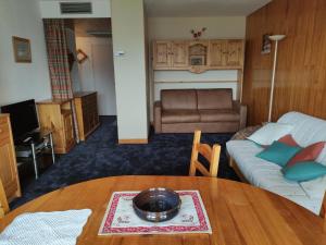 a living room with a table and a couch at Appartement La Toussuire avec vue exceptionnelle in La Toussuire