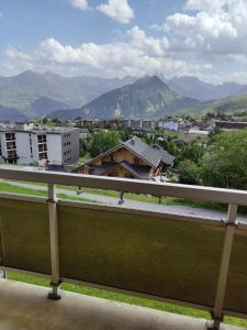 Un balcón con vista a la ciudad y las montañas. en Appartement La Toussuire avec vue exceptionnelle, en La Toussuire