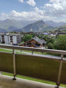 a balcony with a view of a city and mountains at Appartement La Toussuire avec vue exceptionnelle in La Toussuire