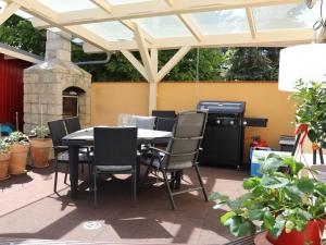 een patio met een tafel en stoelen en een grill bij Ferienwohnungen Prihoda in Wilsdruff