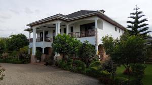 una casa bianca con balcone e alberi di Room in BB - Kilihouse Bb Large Ensuite Double Bedroom a Thika