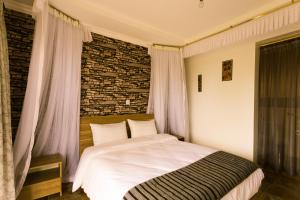 een slaapkamer met een bed en een bakstenen muur bij Kilihouse Bb Large Ensuite Double Bedroom in Thika
