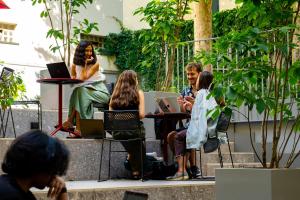 un grupo de personas sentadas en una mesa con ordenadores portátiles en 21 House of Stories Città Studi, en Milán