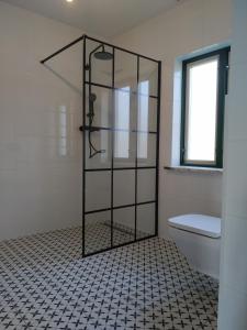 a shower with a glass door in a bathroom at Podroże Chëcz in Charbrowo