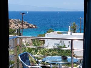 een tafel en stoelen op een balkon met uitzicht op de oceaan bij Ela Mesa in Souvala