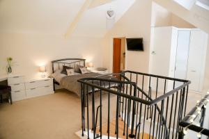a bedroom with a bed and a staircase with a television at Beautiful cozy 3 bedroom 2 bathroom apartment in Newcastle upon Tyne