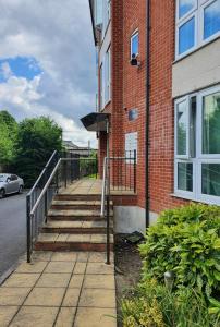 a brick building with a staircase next to a street at global relocation 2 Bed Apt Near Hatfield Station Free Parking in Hatfield